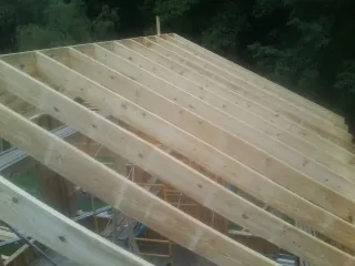New roof rafters set over an addition before sheathing in Marshall